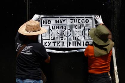 Familias de desaparecidos pegan fichas de búsqueda en el Estadio inaugural del Mundial