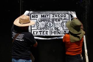 Familias de desaparecidos pegan fichas de búsqueda en el Estadio inaugural del Mundial